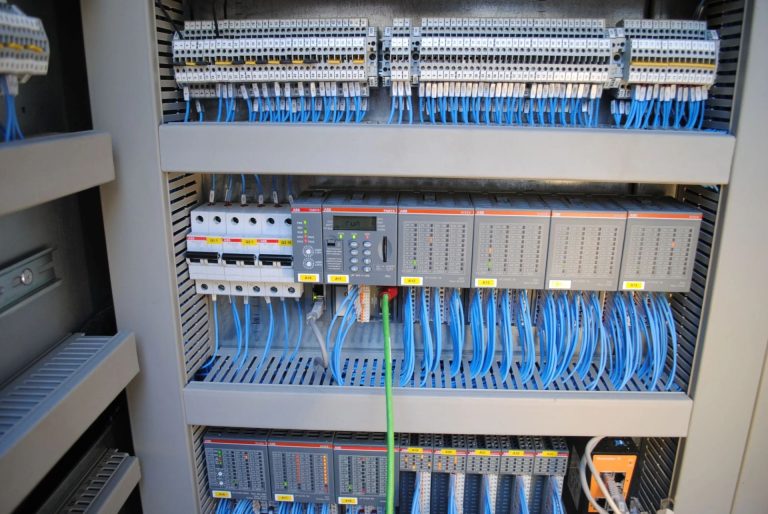 Inside a control panel with an ABB AC500 PLC and terminal blocks wired by TD2E